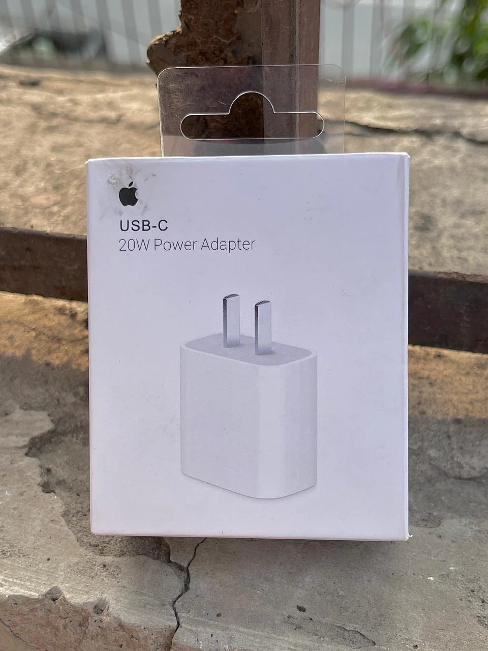 Apple USB-C power adapter packaging on a concrete surface