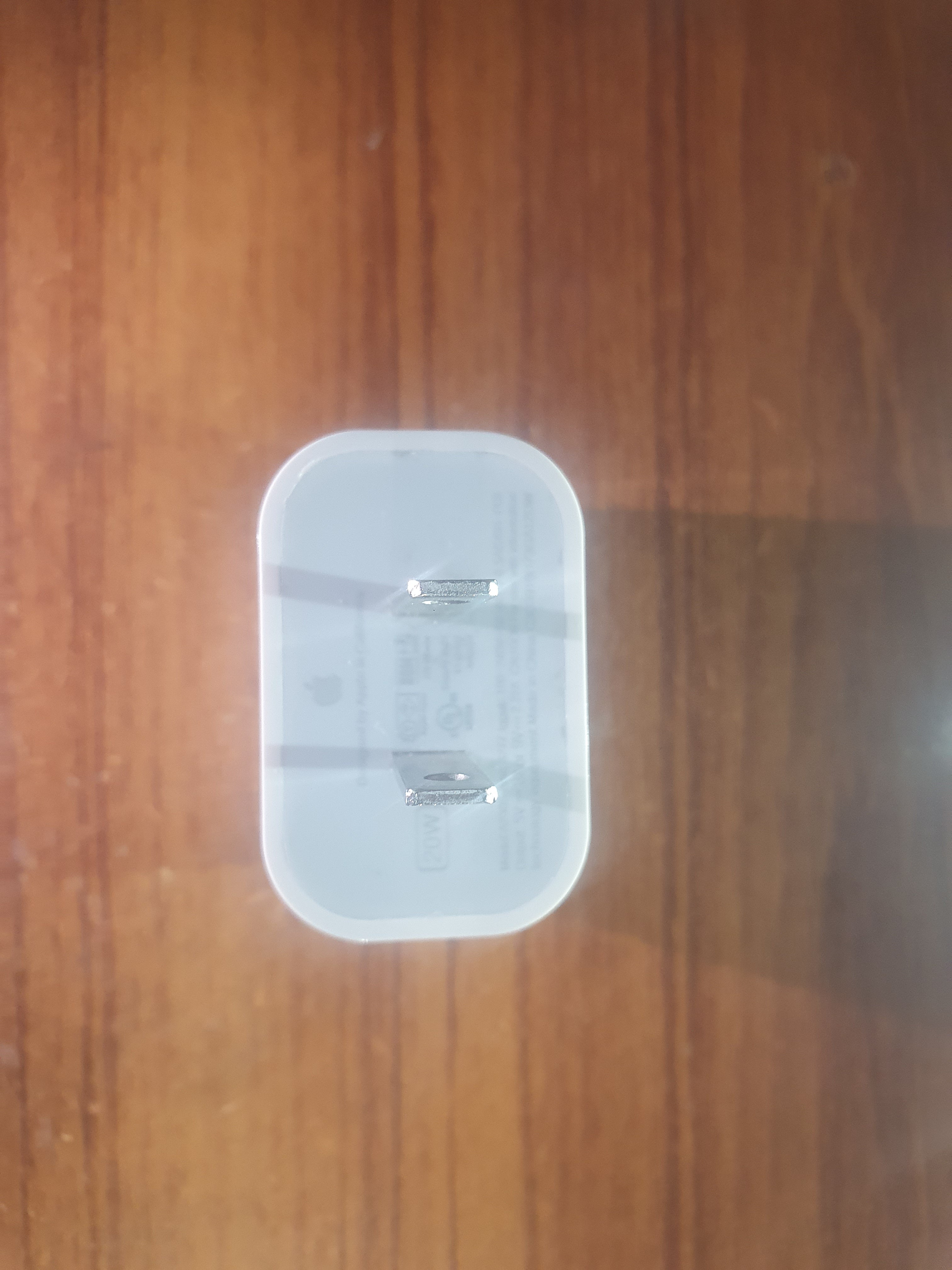 Clear Iphone Apple USB C 20W charger stand on a wooden surface