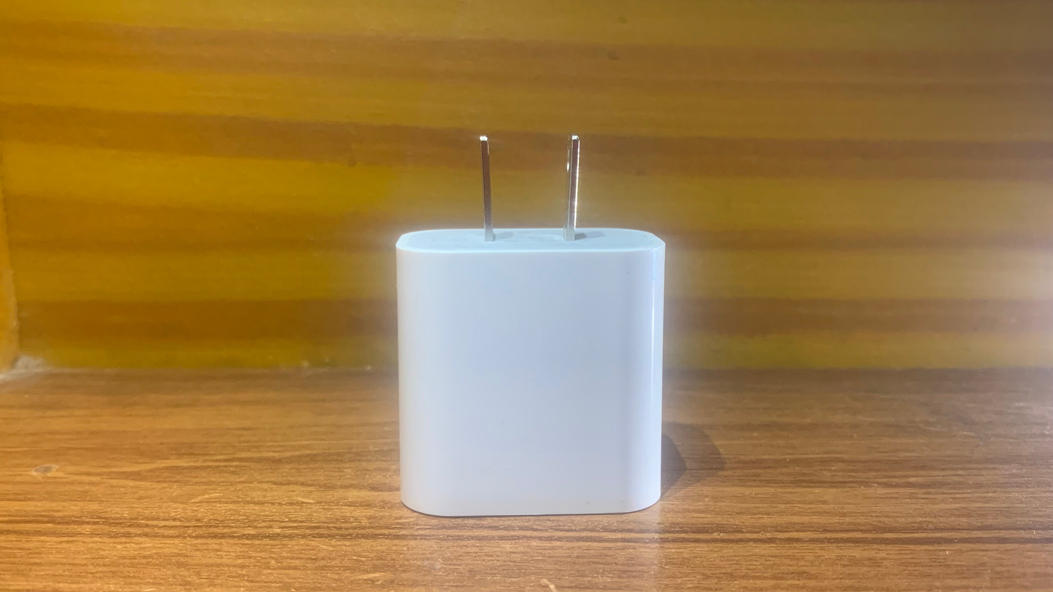 White USB charging adapter on a wooden surface